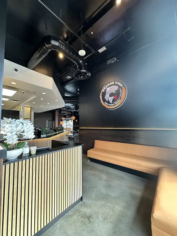 Warm lighted dining tables inside Orange Fish Sushi